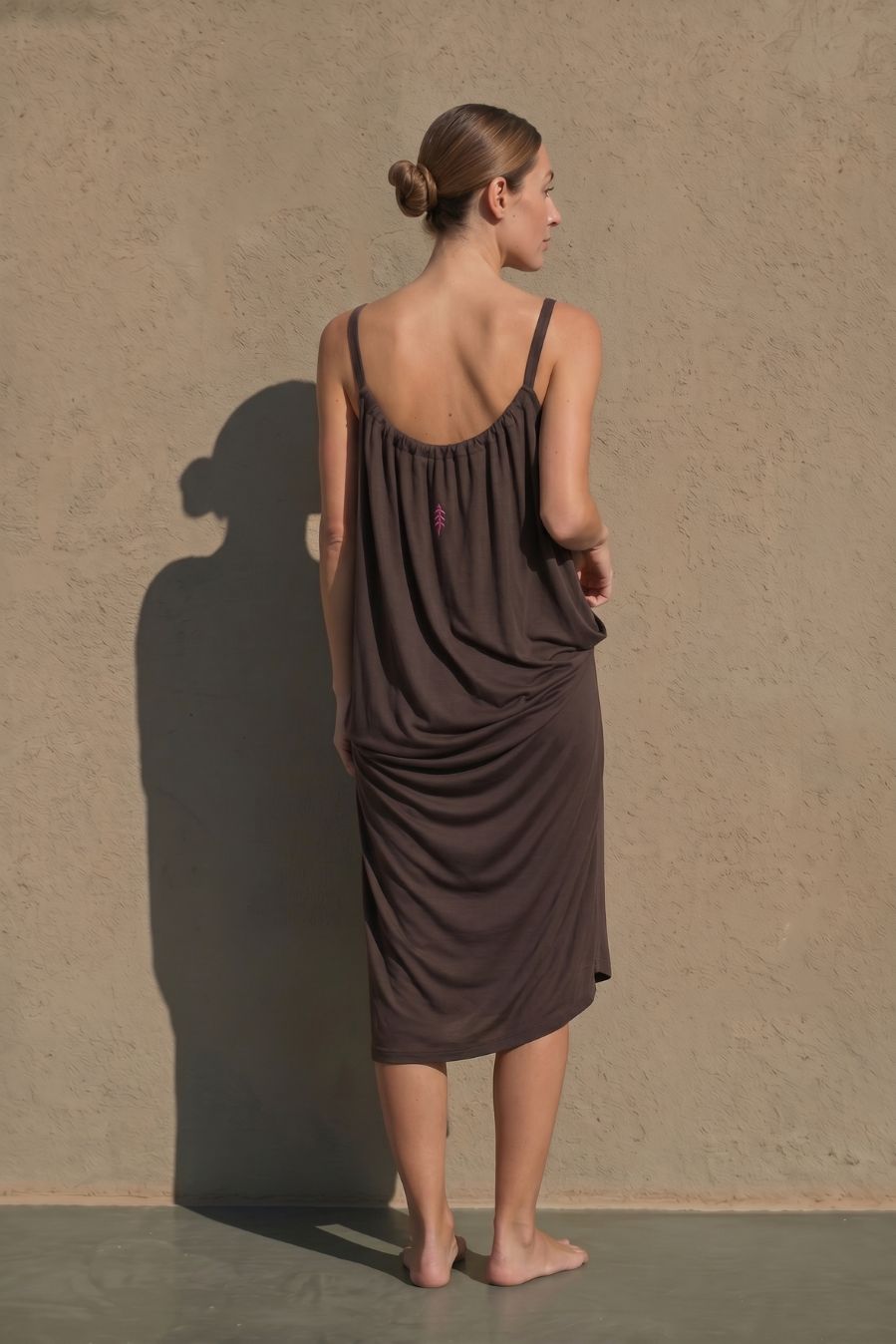 Vestido marrón largo de viscosa con silueta amplia y detalle vertical a contraste. Su tejido suave y ligero aporta movimiento y comodidad.