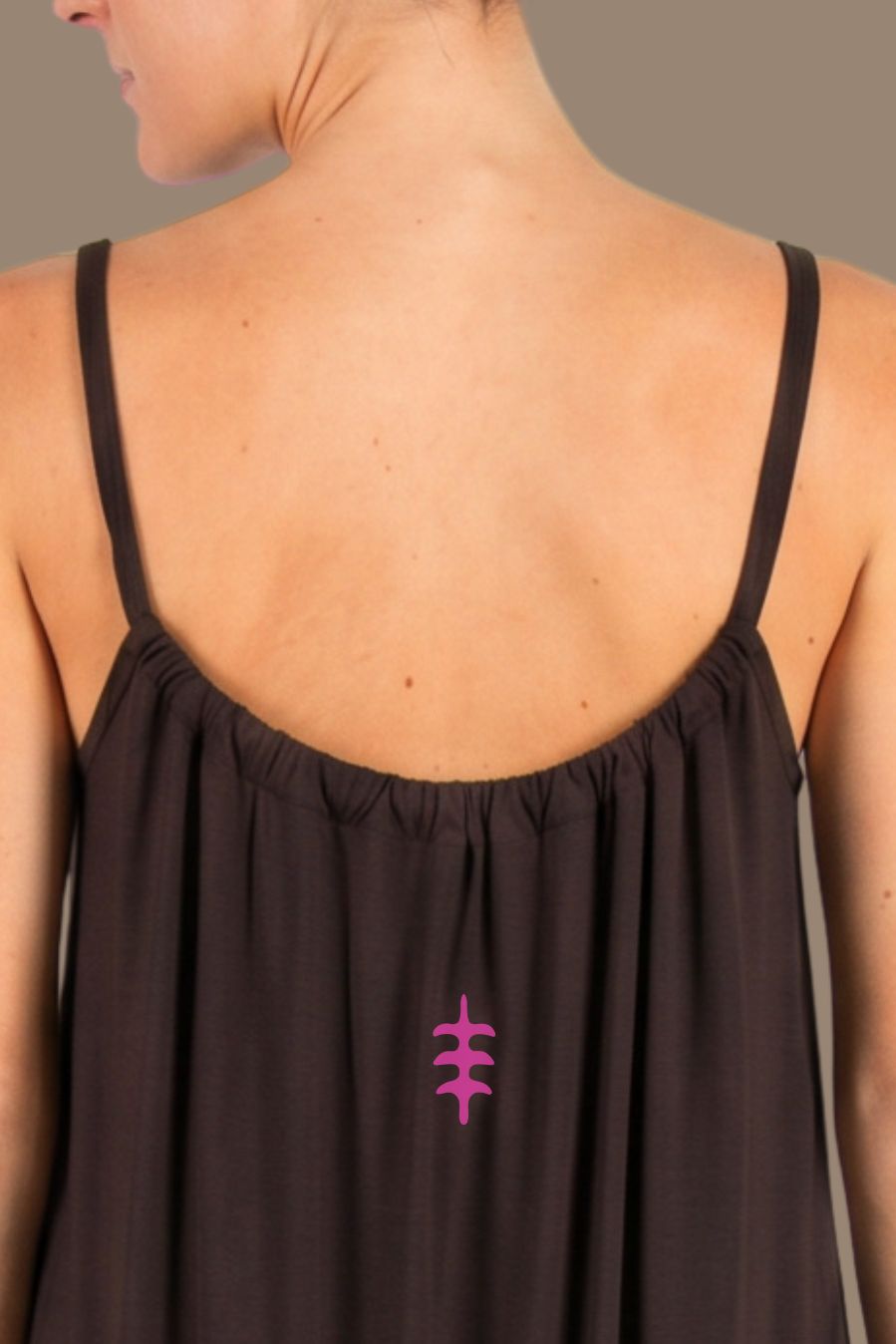 Vestido marrón confeccionado en viscosa transpirable, con tirantes finos y una línea central a contraste que estiliza visualmente la figura.