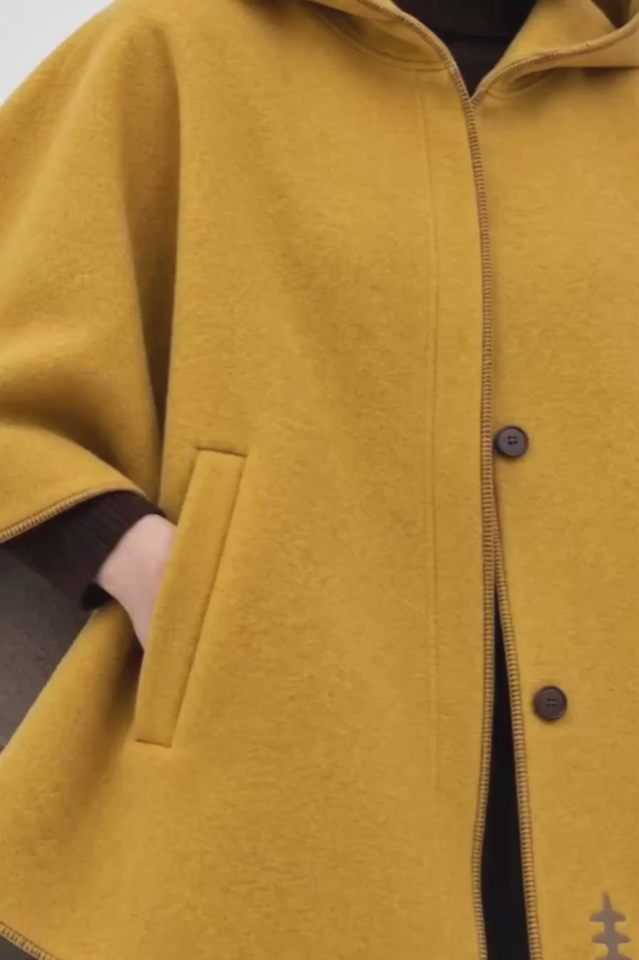 Detalle del tejido de lana cocida y el bolsillo del abrigo capa mostaza